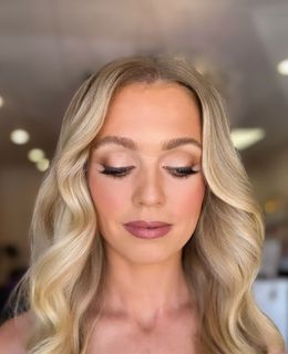 A woman is getting her makeup done by a makeup artist.