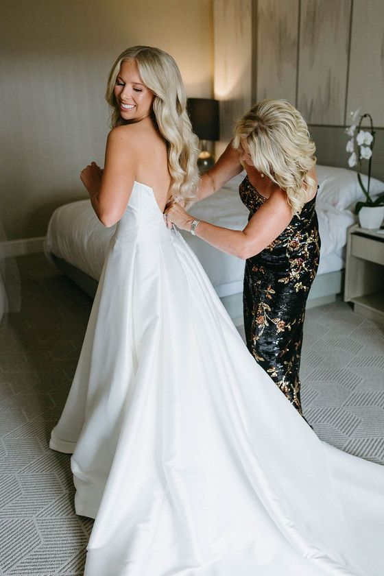 A vanity with a mirror and a vase of flowers on it.