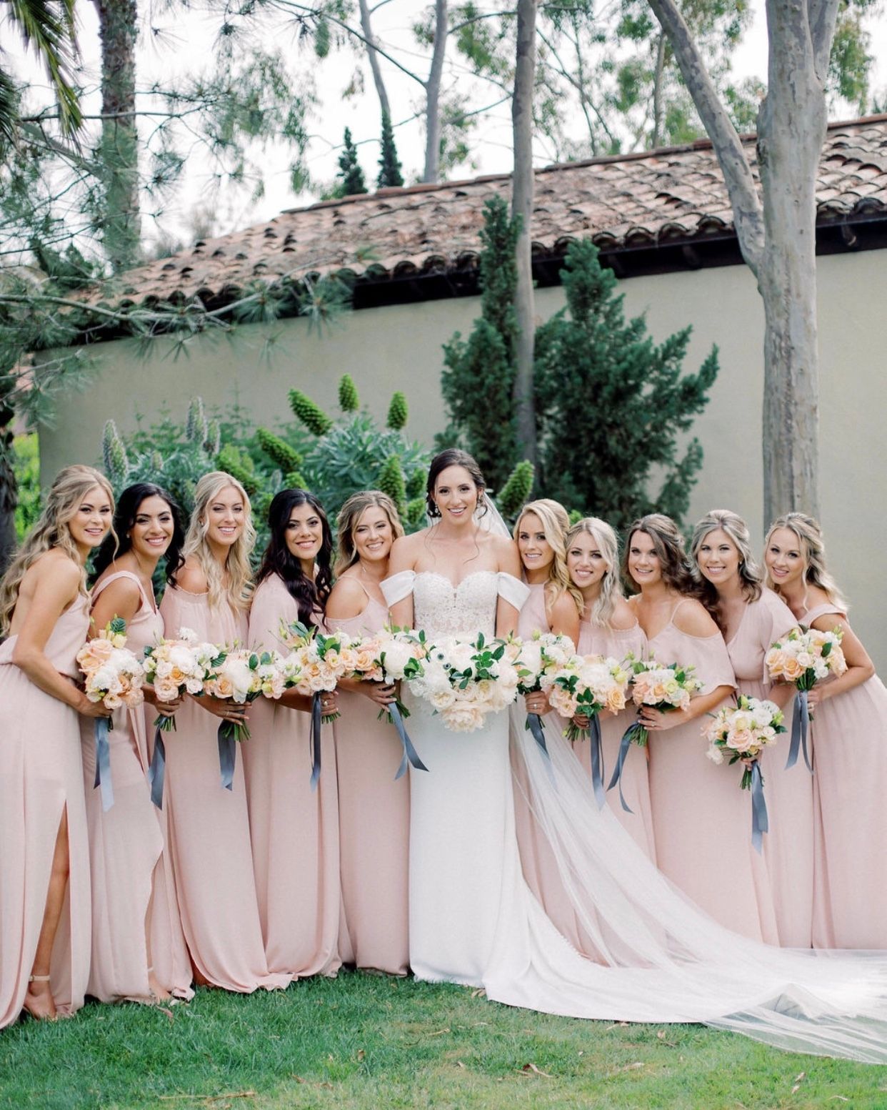 A bride and her bridesmaids are posing for a picture.