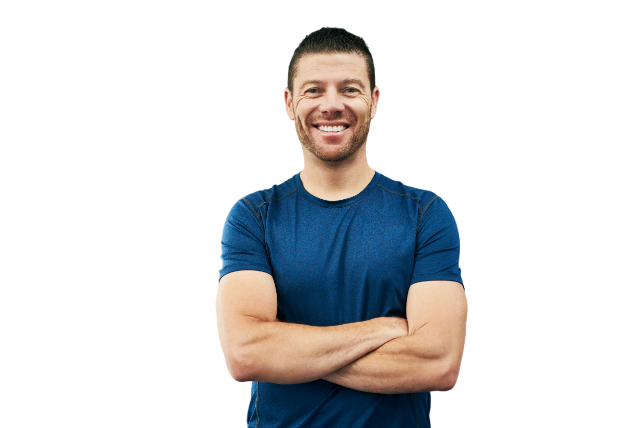 Man with a beard in a blue shirt smiles with arms crossed against a white background.