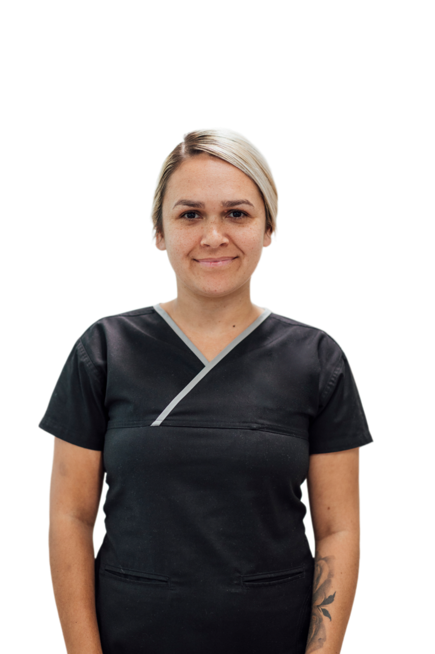 Woman with short blonde hair, wearing black scrubs, smiling, against a white background.