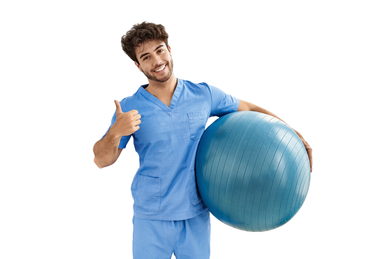 Man in blue scrubs giving a thumbs up while holding a large blue exercise ball, smiling.