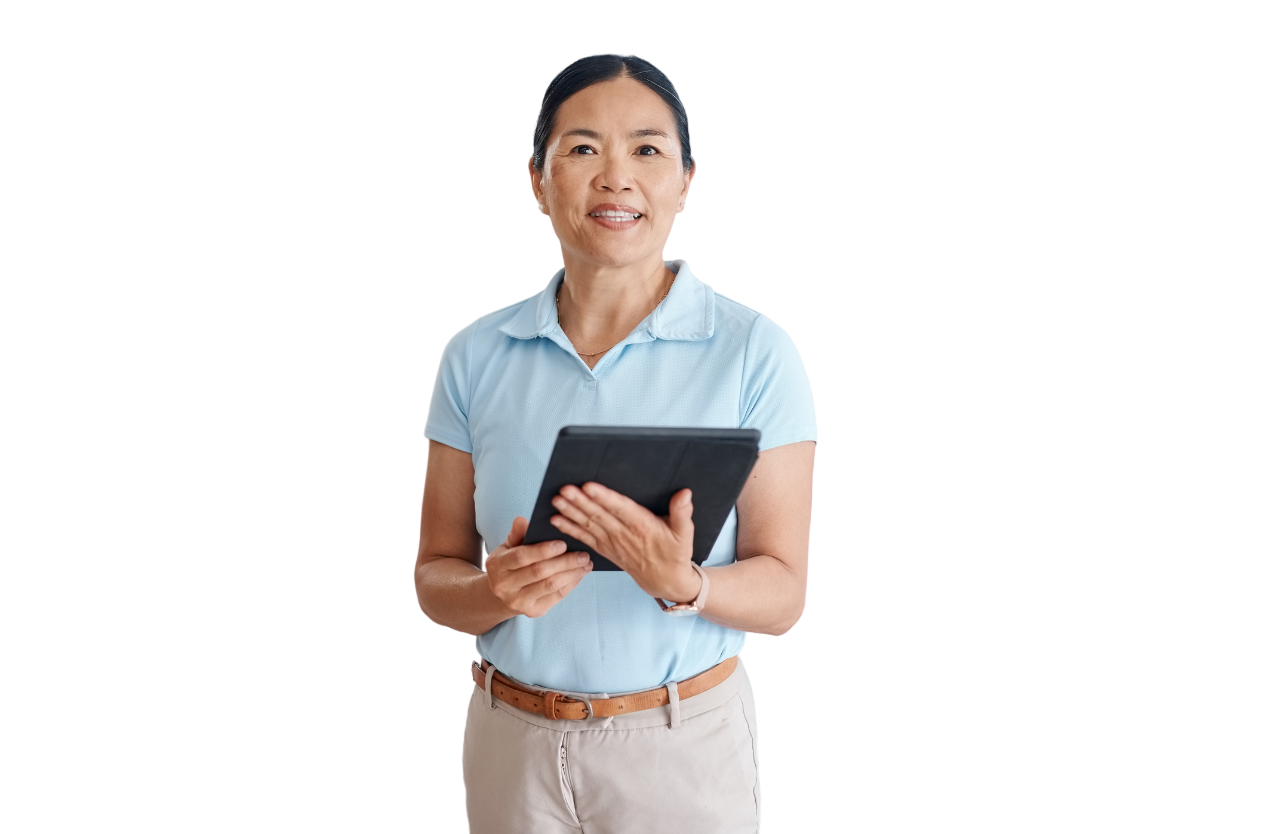 Woman in light blue shirt holds a tablet, smiling at the camera. She is standing against a white background.