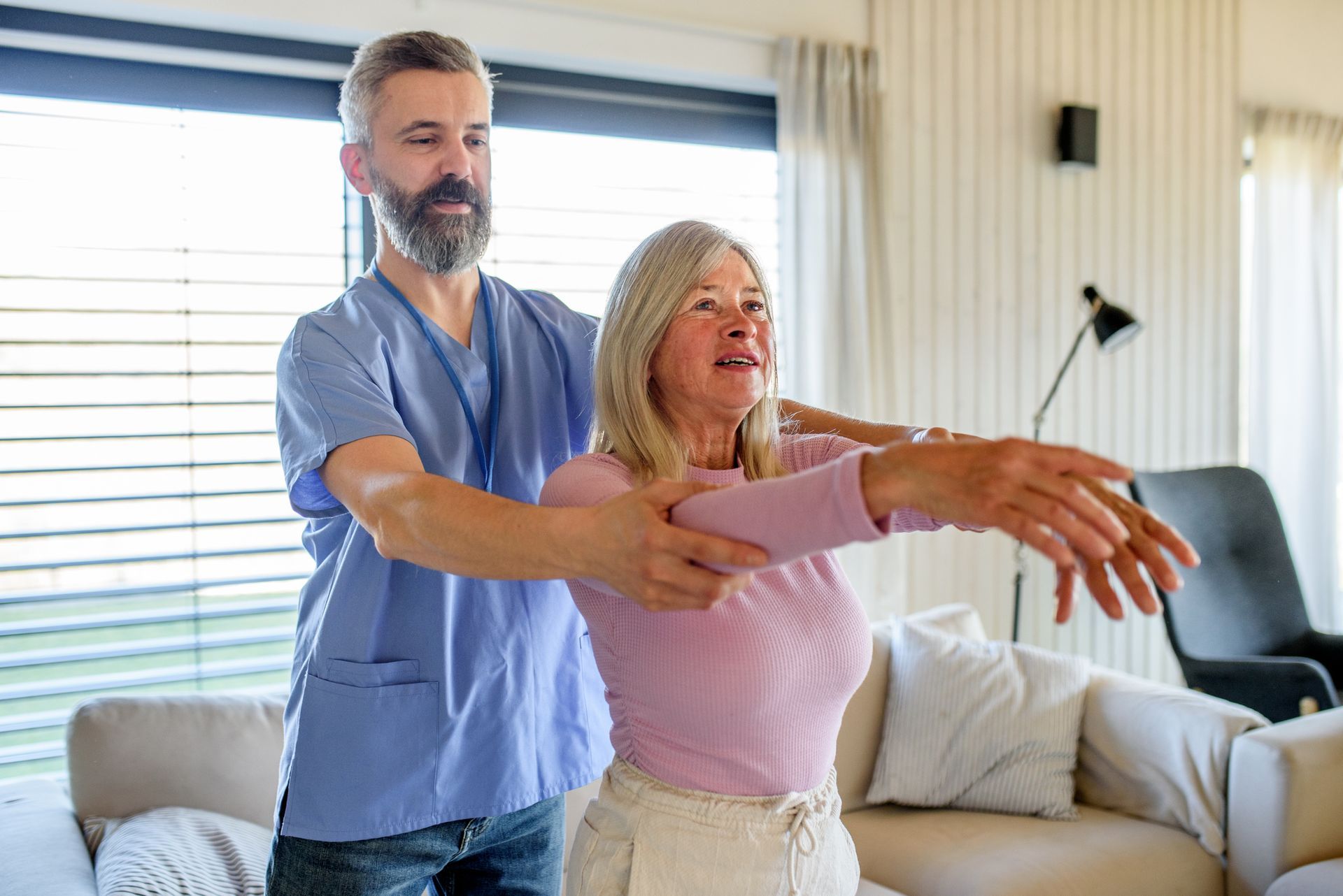 Elderly woman doing arm exercises with help from male therapist, concept of find physiotherapist.