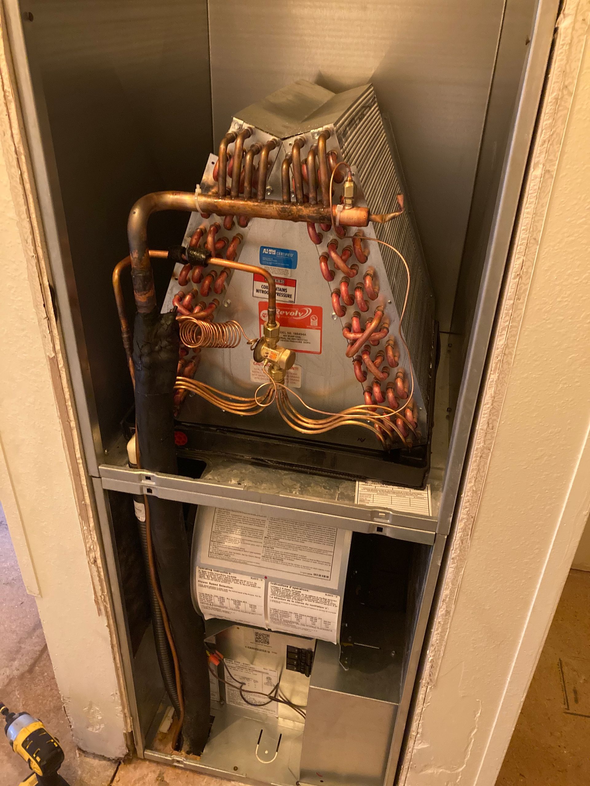 The inside of an air conditioner with copper pipes coming out of it.