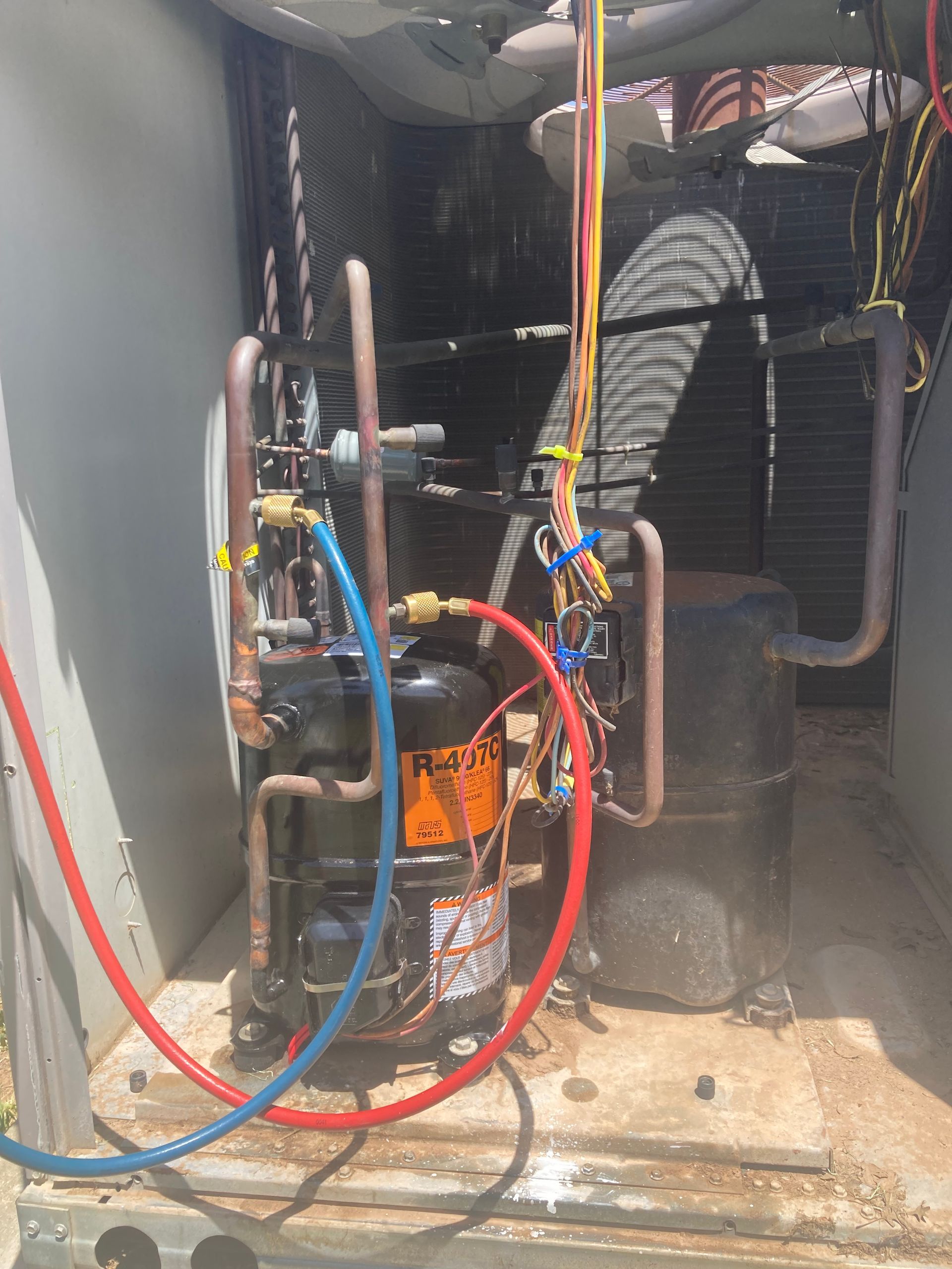 A compressor is being repaired in a room with hose attached to it.