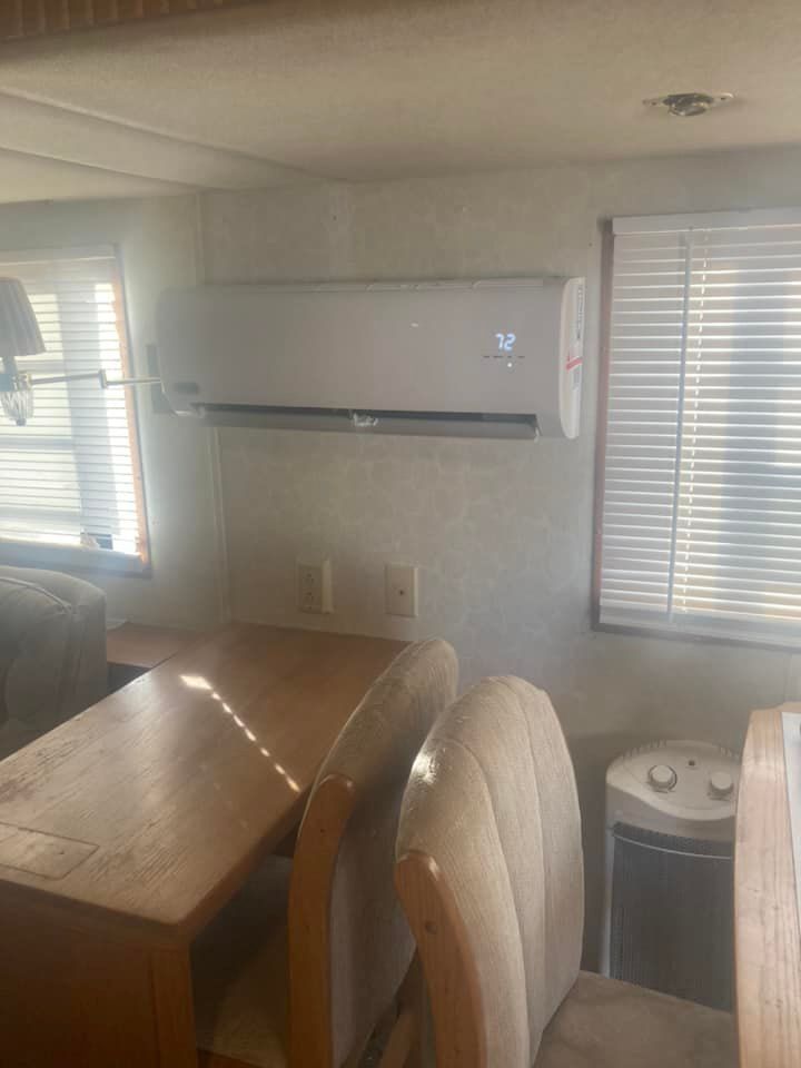 A dining room with a table and chairs and a window with blinds.