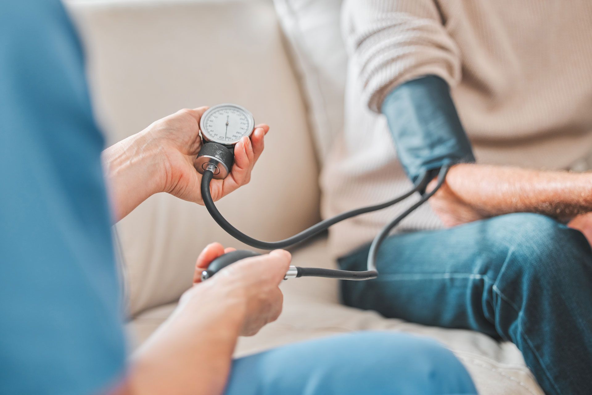 A person's blood pressure is measured by a medical professional using a sphygmomanometer.