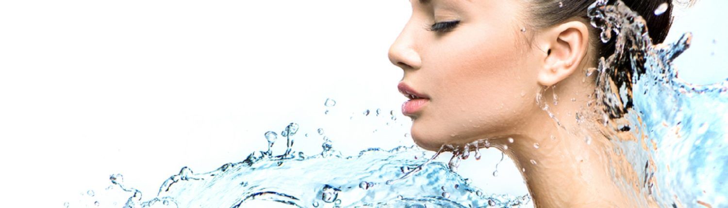 Eine Nahaufnahme des Gesichts einer Frau, um das Wasser spritzt.