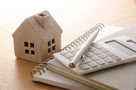 House model next to a notebook and calculator