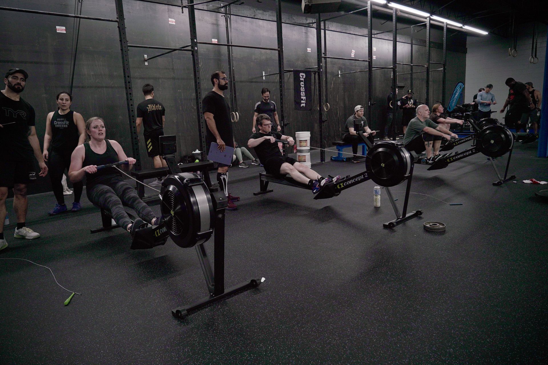 A group of people are rowing rowing machines in a gym.