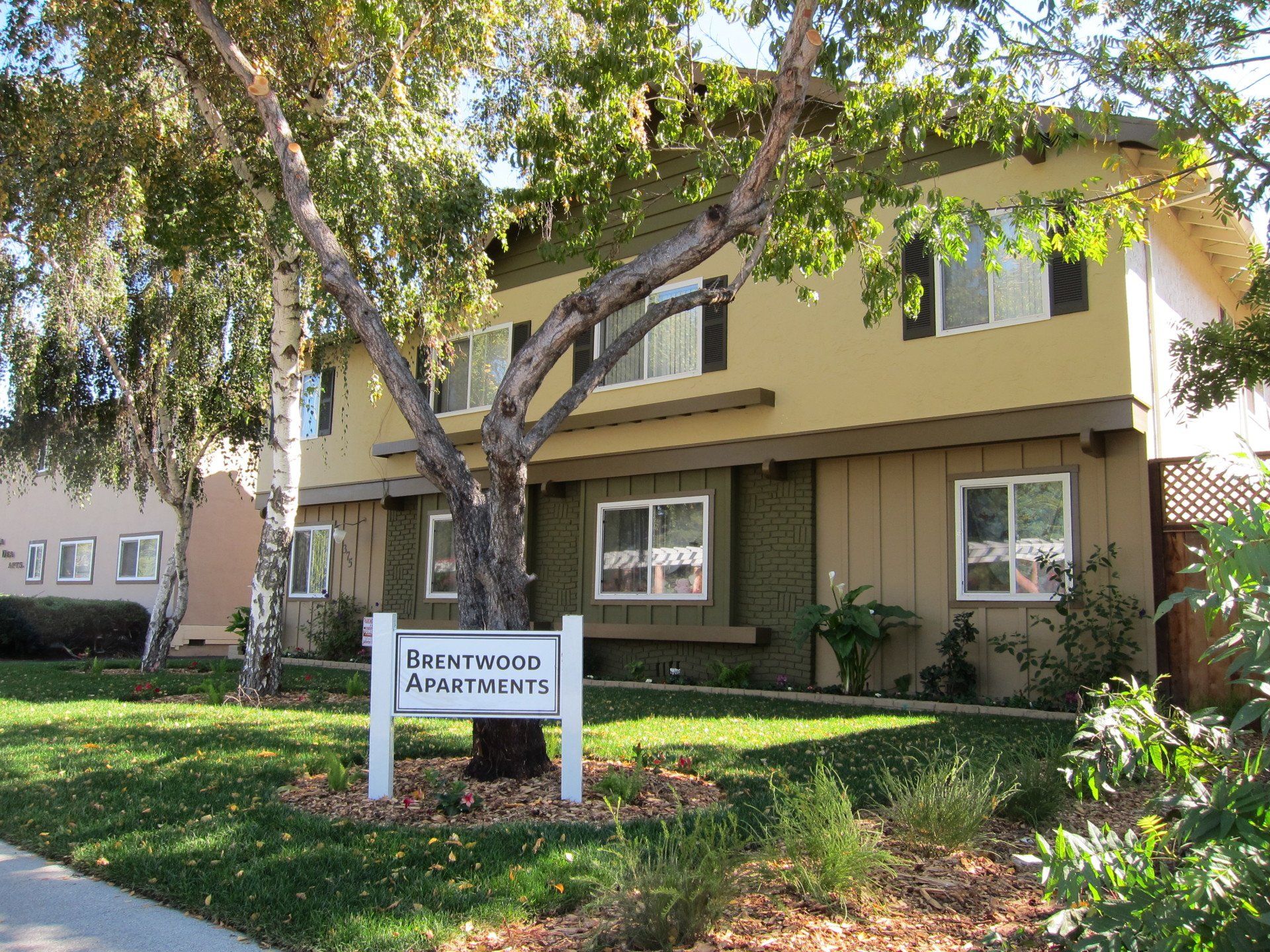 A house with a sign in front of it that says brentwood apartments