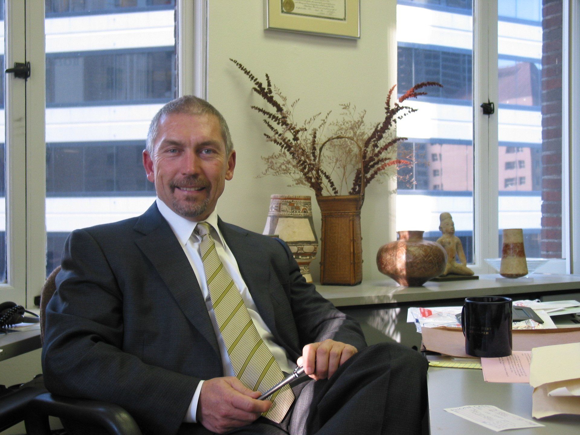 A man in a suit and tie is sitting at a desk