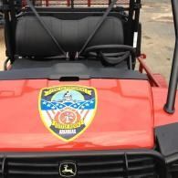 Red utility vehicle hood with a city police-style badge and black seats behind it