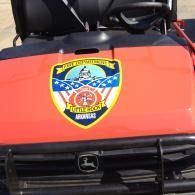 Orange fire rescue vehicle hood with department emblem centered on the front grille