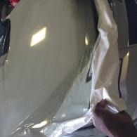 Hand holding a crinkled silver reflective sheet close-up