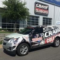Wrapped Crain Collision Center SUV parked outside the shop building