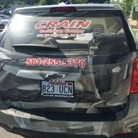 Crushed black SUV rear with CRAIN branding and Arkansas license plate 823 UCN