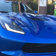 Blue sports car front view with glossy hood and sleek headlights outdoors