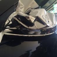 Crumpled silver foil on a dark surface near a window