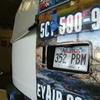 Arkansas license plate 352 PBM on a printed vehicle advertisement banner