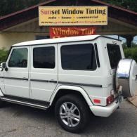 White SUV parked outside Sunset Window Tinting shop sign