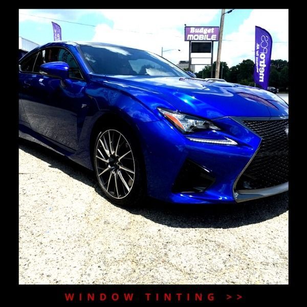 Blue Lexus sedan parked outdoors with dark tinted windows, promoting window tinting