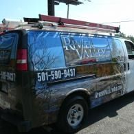 Branded van with “River Valley” graphics, phone number, and ladder on top, parked outdoors
