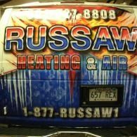 Truck banner for Russaw Heating & Air, with large red and blue lettering and phone number