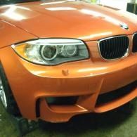 Front view of an orange BMW sports car with silver headlights and grille