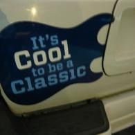 Blue car decal reading “It’s Cool to be Classic” on a cream vehicle door