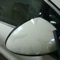 White car side mirror with water droplets close-up