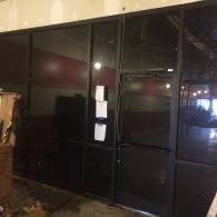 Dark storefront with black-framed glass doors and windows at night