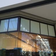 Modern glass building corner with large windows and a reflective facade