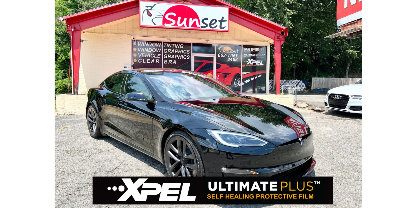 Black sports sedan at Sunset car wash with XPEL Ultimate Plus banner