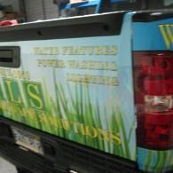 Close-up of a colorful utility truck rear with advertising text and taillights