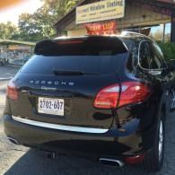 Rear view of a black Porsche SUV parked outdoors with a visible license plate.