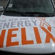 Car hood wrapped in white and orange with large “HELIX” and “ENERGY X” text