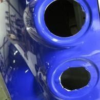 Blue vehicle body panel with two circular openings and a glossy finish