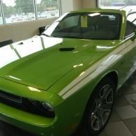 Bright green sports car parked indoors under showroom lighting