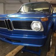 Blue classic BMW coupe parked in a garage, front-left view