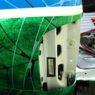 Close-up of a green and blue striped object with a white mounting bracket and exposed screws