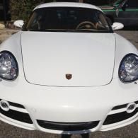 Front view of a white Porsche sports car parked outdoors at night