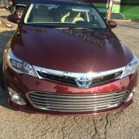 Maroon Toyota sedan parked on a street, front view