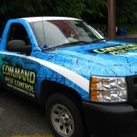 Blue pest control pickup truck with “Command Pest Control” lettering parked outdoors