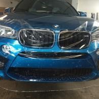 Blue BMW sedan front view parked indoors