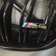 Close-up of a BMW M grille with the tri-color M badge.