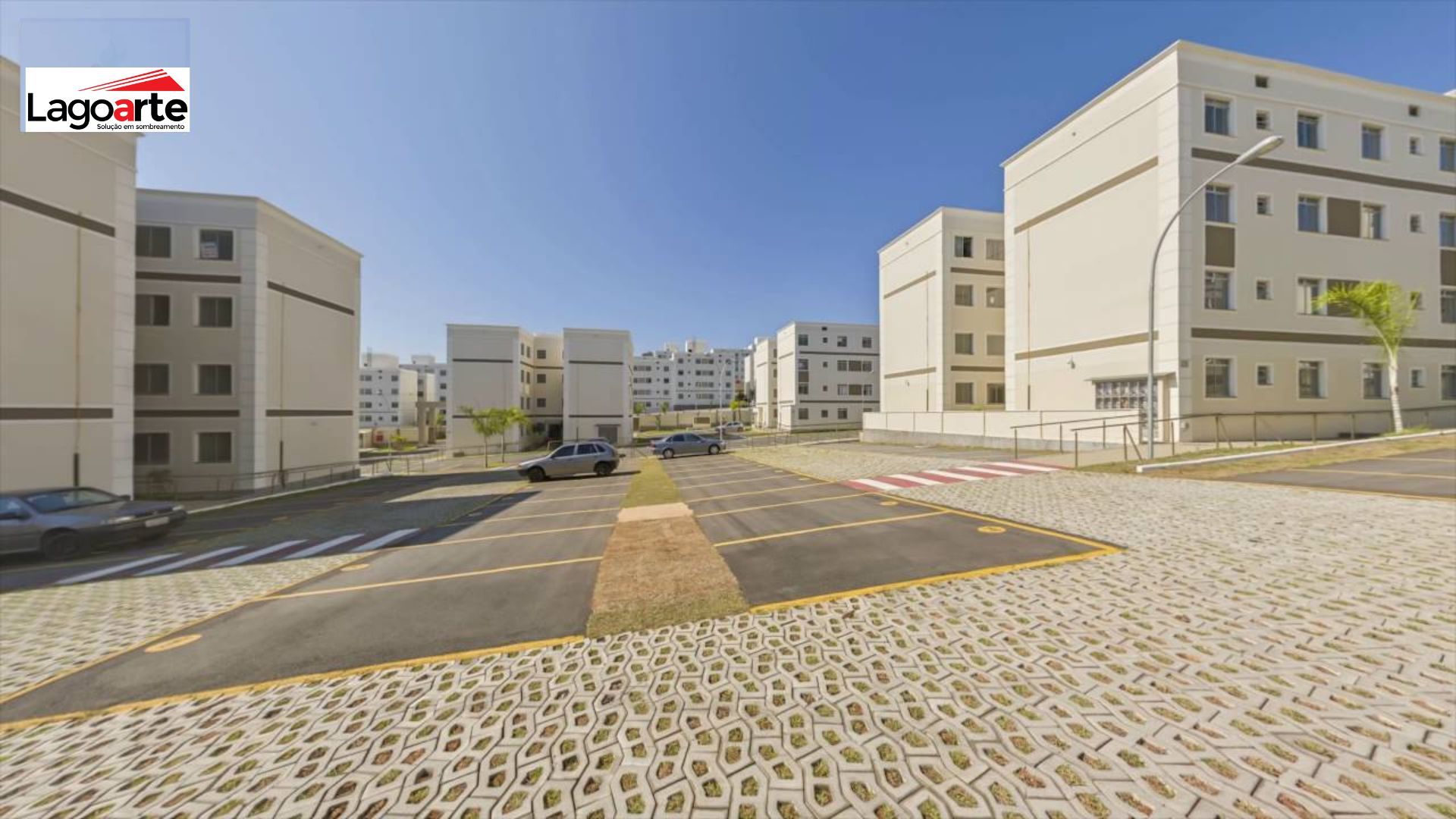 Uma fileira de prédios de apartamentos com carros estacionados na frente deles em uma área residencial.