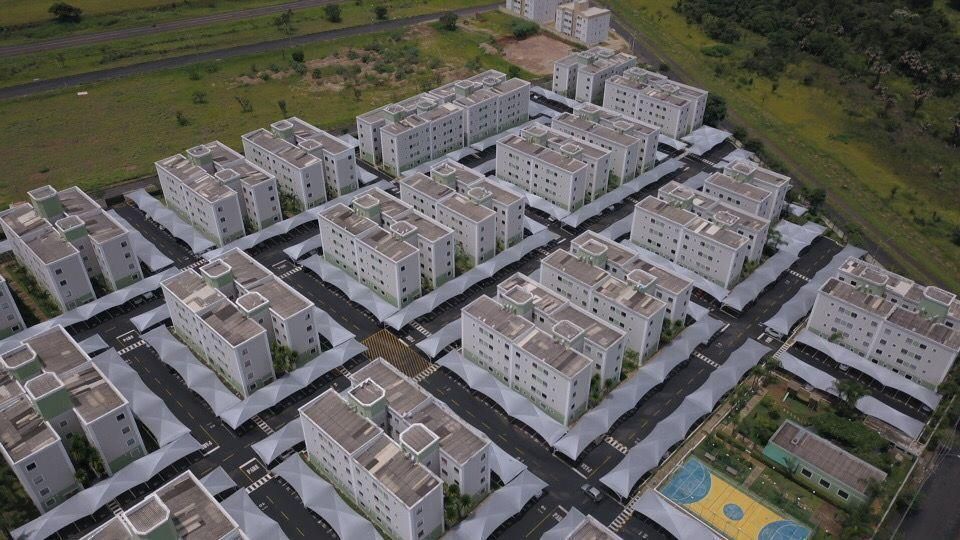 Uma vista aérea de uma área residencial com muitos edifícios e uma quadra de basquete.