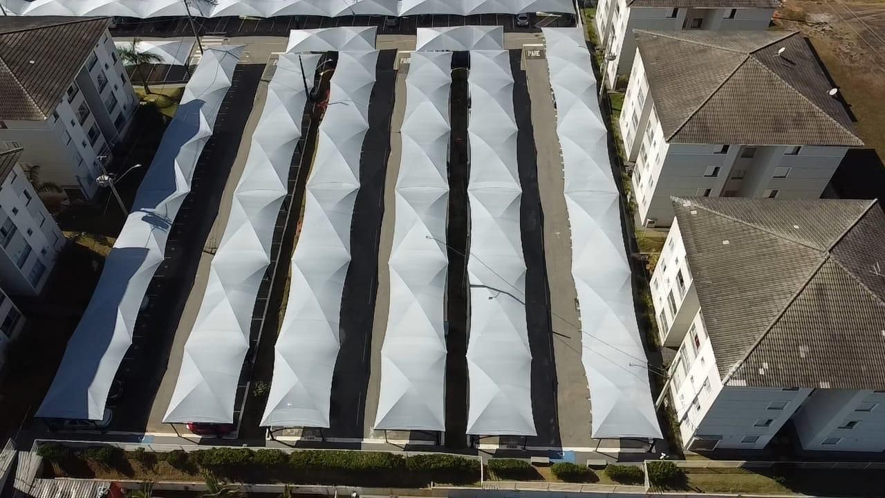 Uma vista aérea de uma fileira de tendas brancas em um estacionamento